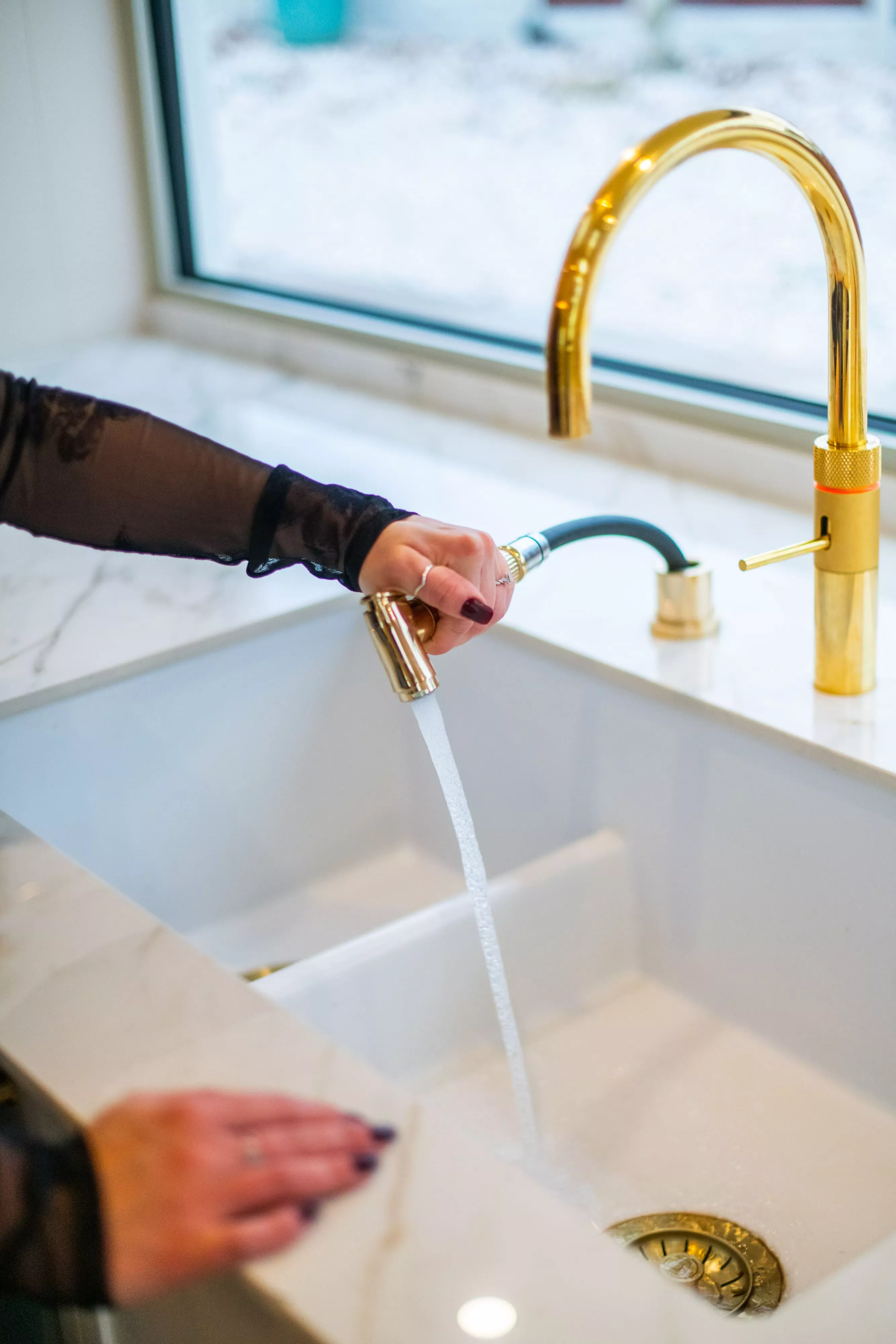 close up of someone using gold quooker tap