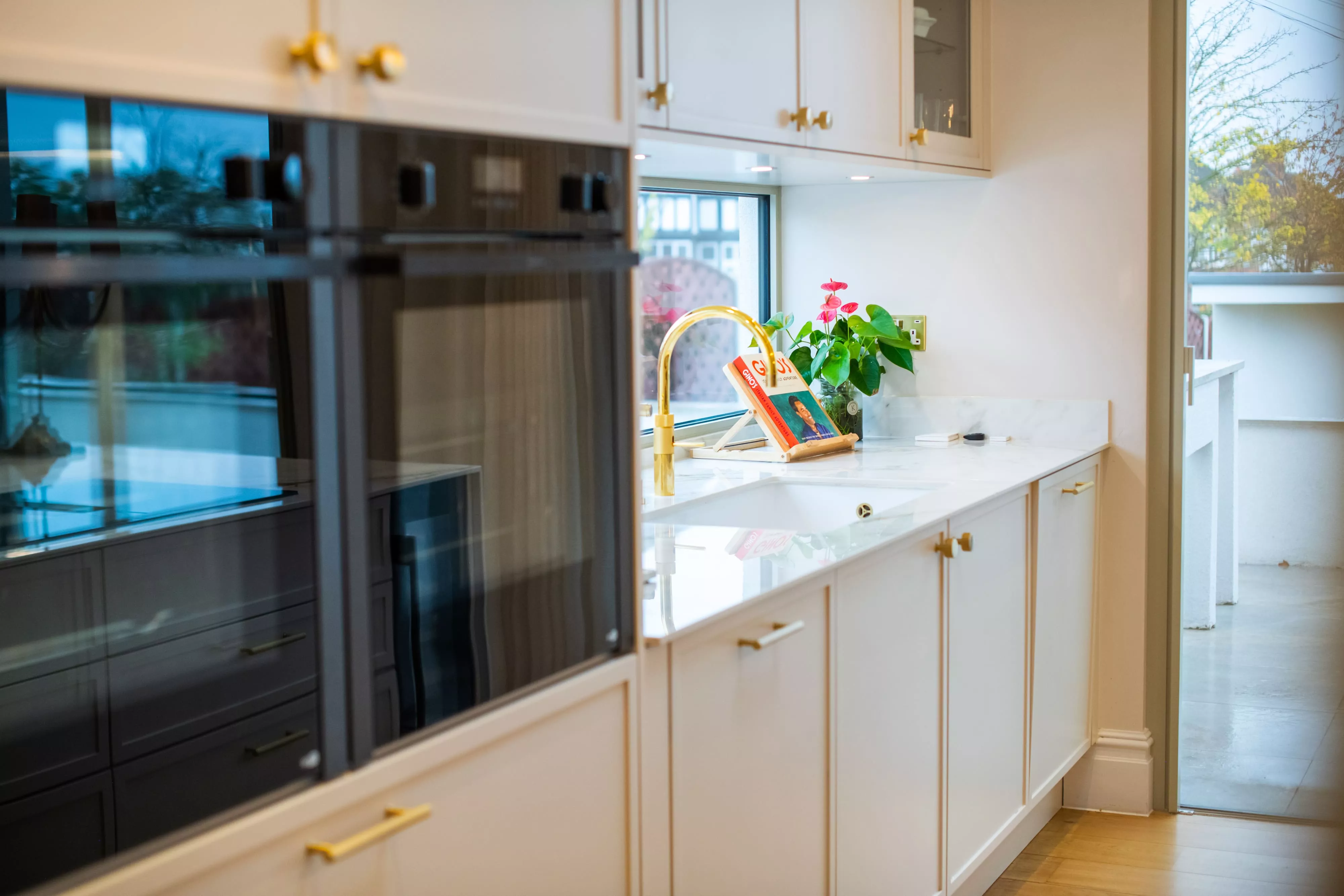 close up of NEFF ovens in white kitchen with gold accents